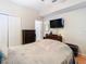 Cozy bedroom featuring a TV, neutral walls, and a double-door closet for ample storage space at 4262 Larkenheath Dr, Spring Hill, FL 34609