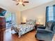 This bedroom boasts wood floors, a comfy chair, and access to a screened patio at 4262 Larkenheath Dr, Spring Hill, FL 34609