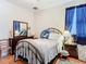Comfortable bedroom with blue curtains, and warm-toned hardwood flooring throughout at 4262 Larkenheath Dr, Spring Hill, FL 34609