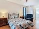 Comfortable bedroom with decorative quilt on bed, wood floors, and reading chair at 4262 Larkenheath Dr, Spring Hill, FL 34609