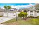 Charming home featuring a three-car garage, manicured lawn, and solar panels on the roof at 4262 Larkenheath Dr, Spring Hill, FL 34609