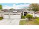 Inviting home exterior with a three-car garage, manicured lawn, and solar panels for sustainability at 4262 Larkenheath Dr, Spring Hill, FL 34609