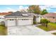 Attractive single-Gathering home with a three-car garage, lush landscaping, and well-maintained lawn at 4262 Larkenheath Dr, Spring Hill, FL 34609
