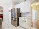 Well-lit kitchen with stainless steel refrigerator and view of the adjacent dining room at 4262 Larkenheath Dr, Spring Hill, FL 34609