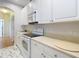Bright kitchen with white appliances, cabinets, marble flooring and view into the adjacent hallway at 4262 Larkenheath Dr, Spring Hill, FL 34609