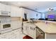Bright kitchen featuring white appliances, marble floor and a view into the living room at 4262 Larkenheath Dr, Spring Hill, FL 34609