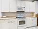 Bright kitchen featuring white cabinets, appliances, and marble floors at 4262 Larkenheath Dr, Spring Hill, FL 34609