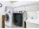 Laundry room with a white washer and a silver dryer, plus a utility sink and wire shelving at 4262 Larkenheath Dr, Spring Hill, FL 34609