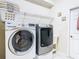 Laundry room features a white washer, silver dryer, sink and overhead wire rack at 4262 Larkenheath Dr, Spring Hill, FL 34609