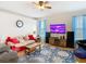 This charming living room has wood floors, a tv, and seating including a sofa and chair at 4262 Larkenheath Dr, Spring Hill, FL 34609
