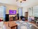 Bright living room featuring wood floors, a large screen tv, and sliding doors to a patio at 4262 Larkenheath Dr, Spring Hill, FL 34609