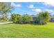 Lush backyard with mature trees, a well-maintained lawn, and a view of the home's exterior at 4811 Forest Creek Trl, Parrish, FL 34219