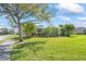 Manicured lawn and mature palm trees surround the screened in lanai of this attractive single-Gathering home at 4811 Forest Creek Trl, Parrish, FL 34219