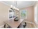 Bright dining room with natural lighting, modern chandelier, and views of the front yard at 4811 Forest Creek Trl, Parrish, FL 34219