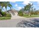 View of the home featuring a two-car garage, well-maintained lawn, and mature trees at 4811 Forest Creek Trl, Parrish, FL 34219