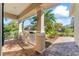 Covered front porch with brick flooring, white railing, and landscaped garden at 4811 Forest Creek Trl, Parrish, FL 34219