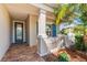 Inviting front porch with brick flooring, decorative columns, and a charming blue door at 4811 Forest Creek Trl, Parrish, FL 34219