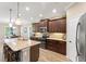 Gourmet kitchen features granite counters, dark wood cabinetry, stainless appliances, and breakfast bar at 4811 Forest Creek Trl, Parrish, FL 34219