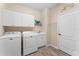 Functional laundry room with ample storage, washer, dryer, utility sink, and tile flooring at 4811 Forest Creek Trl, Parrish, FL 34219