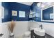 Stylish powder room featuring wainscoting, blue walls, decorative mirror, and vessel sink at 4811 Forest Creek Trl, Parrish, FL 34219