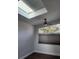 Bedroom features a skylight, ceiling fan, and narrow horizontal window with dark wood-look flooring at 500 New York Ave # 21, Dunedin, FL 34698