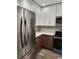 Contemporary kitchen featuring stainless steel refrigerator, white cabinetry, and modern microwave at 500 New York Ave # 21, Dunedin, FL 34698