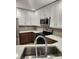 Well-lit kitchen boasting modern stainless steel appliances, white cabinetry, and double sink at 500 New York Ave # 21, Dunedin, FL 34698
