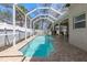 A sparkling swimming pool surrounded by a screened enclosure and a brick patio at 5001 44Th N Ave, St Petersburg, FL 33709