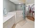 Bathroom featuring a tub with shower, dual vanities and walk-in closet at 6495 Shoreline Dr # 8105, Seminole, FL 33708