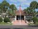 Community clubhouse surrounded by lush landscaping and palm trees at 6495 Shoreline Dr # 8105, Seminole, FL 33708