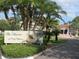 Inviting entrance sign to The Shores of Long Bayou surrounded by lush landscaping and mature palm trees at 6495 Shoreline Dr # 8105, Seminole, FL 33708