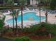 View of the beautiful community pool with plenty of seating and lush tropical landscaping at 6495 Shoreline Dr # 8105, Seminole, FL 33708