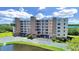 Low aerial view of a seven-story condo building with verdant landscaping and waterfront views at 6495 Shoreline Dr # 8105, Seminole, FL 33708