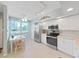 Bright kitchen featuring modern stainless steel appliances, white cabinets and adjacent dining area at 6495 Shoreline Dr # 8105, Seminole, FL 33708