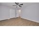 A bedroom features light walls, wood flooring, a ceiling fan, closet, and a door to an adjacent room at 6672 56Th N Ave, St Petersburg, FL 33709