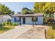 Charming single-story home featuring a covered entry, light blue exterior, and a spacious concrete driveway at 6672 56Th N Ave, St Petersburg, FL 33709