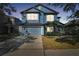 Inviting two-story home features a blue exterior, attached garage, and well-maintained front yard at 6816 Guilford Bridge Dr, Apollo Beach, FL 33572