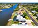 Aerial of a waterfront home with pool, screened lanai, and dock on a sunny day at 7094 Kenwood Dr, North Port, FL 34287