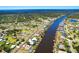 Aerial view of a beautiful waterfront community with canals, homes, docks, and lush greenery under a bright blue sky at 7094 Kenwood Dr, North Port, FL 34287