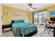 Cozy bedroom with a ceiling fan, desk, and sliding glass door with access to the backyard at 7094 Kenwood Dr, North Port, FL 34287