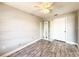 Neutral bedroom featuring wood-look floors, a ceiling fan, and a mirrored storage cabinet at 7094 Kenwood Dr, North Port, FL 34287