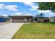 Charming single-story home with a well-maintained lawn, garage, and a stone facade at 7094 Kenwood Dr, North Port, FL 34287