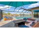 Inviting screened patio with comfortable seating and a stunning view of the pool and waterfront canal at 7094 Kenwood Dr, North Port, FL 34287