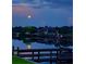 Waterfront home reflecting in the still water at night with a full moon at 7094 Kenwood Dr, North Port, FL 34287