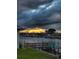 Waterfront homes with private docks under a dramatic sky with sunbeams at 7094 Kenwood Dr, North Port, FL 34287