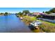 Waterfront property featuring a dock and boat, complemented by a screened lanai for outdoor relaxation at 7094 Kenwood Dr, North Port, FL 34287