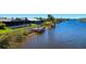 Waterfront property with private dock access, lush lawn and canal views, blue skies at 7094 Kenwood Dr, North Port, FL 34287
