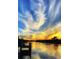Picturesque waterfront view with homes reflected in the water under a beautiful sunset at 7094 Kenwood Dr, North Port, FL 34287