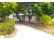 Modest single-story home with a spacious driveway and mature trees, exuding suburban charm at 714 Gray S St, Gulfport, FL 33707