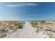 Sandy beach and blue ocean extend to the horizon under a cloud-streaked sky at 805 Bruce Ave, Clearwater Beach, FL 33767